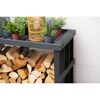 Holzregal mit Kaminholz und Pflanzen