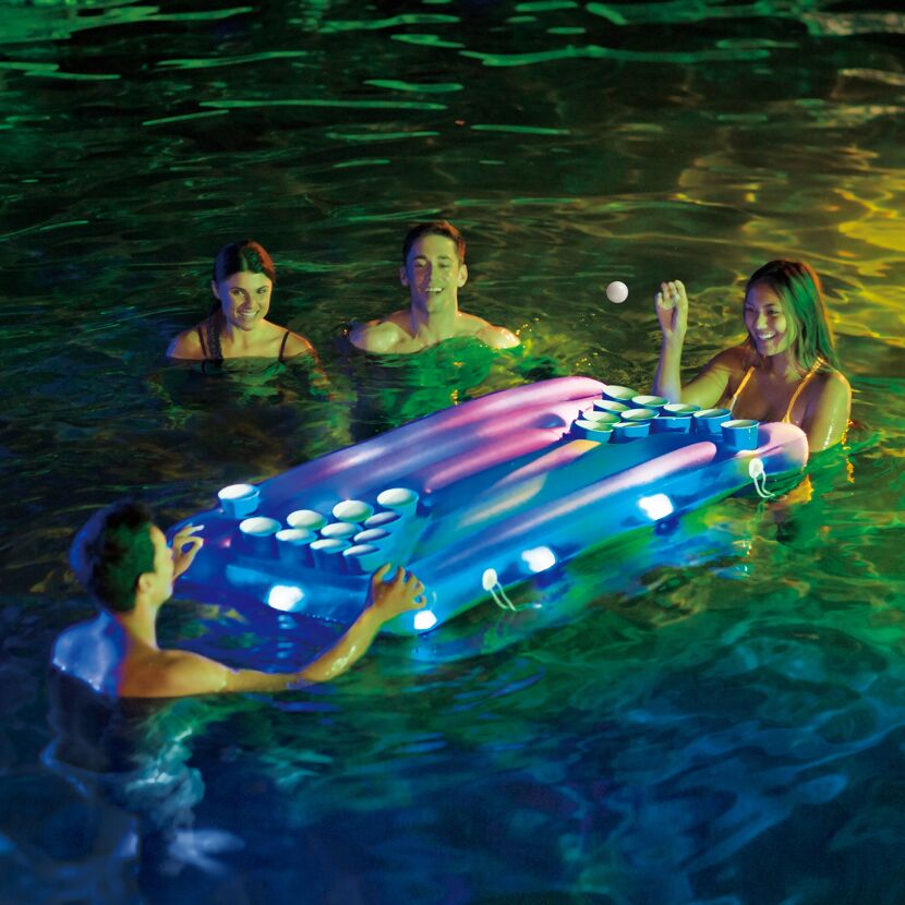 Personen spielen im Pool mit einem Bierpong-Set.