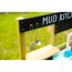 Spielzeug-Pfannenwender und -Suppenkelle hängen an einer Matschküche.