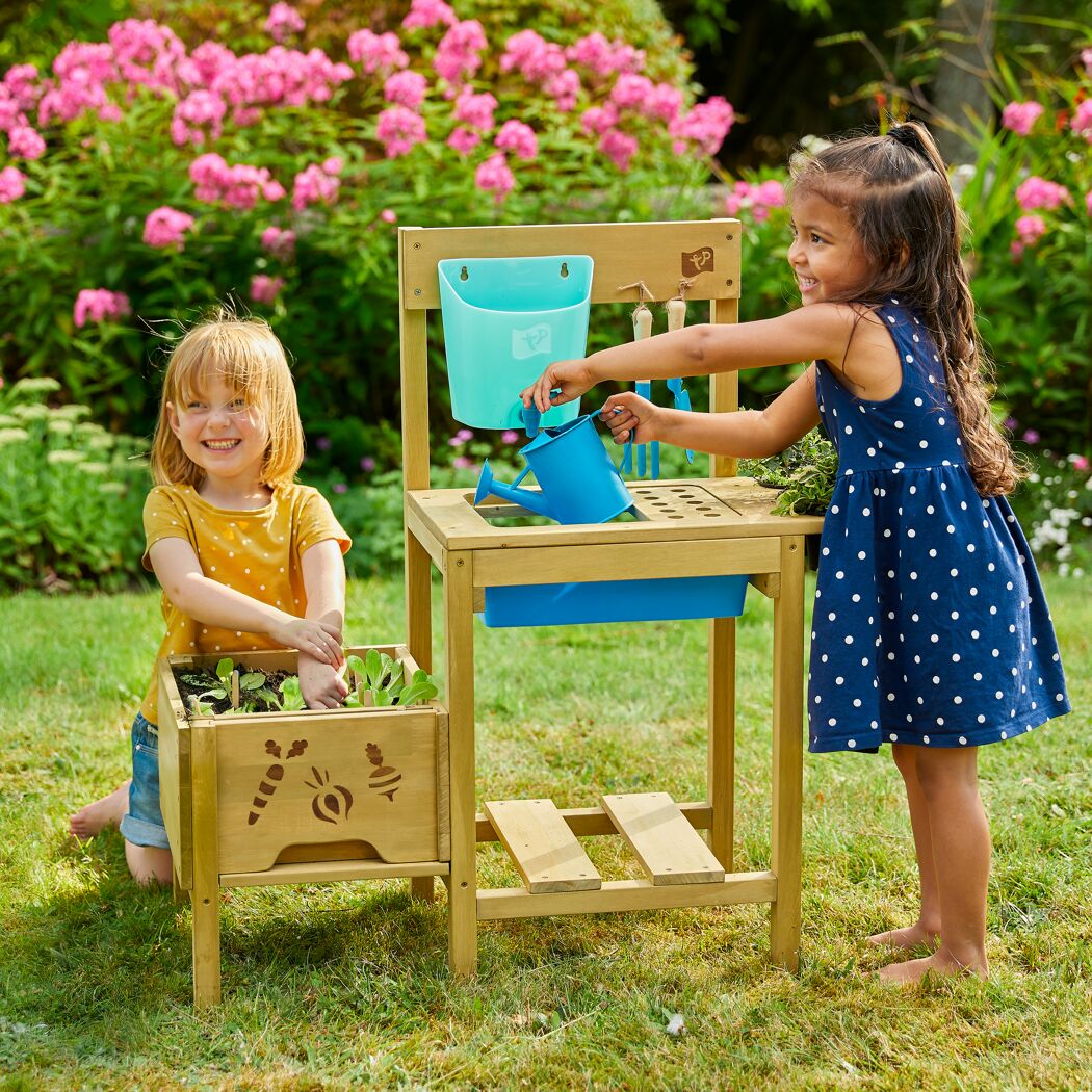 Zwei Kinder spielen mit einer Matschküche.
