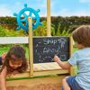 Zwei Kinder spielen mit Kreide an einem Spielsandkasten.