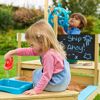 Zwei Kinder spielen in einem Sandkasten mit Spielzeugbooten.