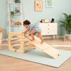 Kleinkind klettert auf Spielzeug-Rutsche aus Holz.