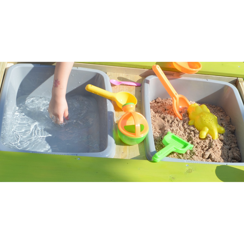 Kind spielt mit Wasser und Sandkasten