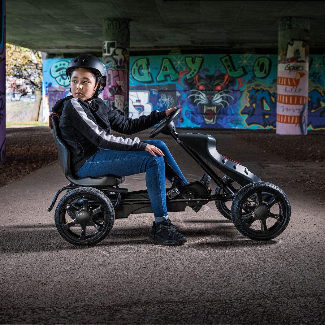 Kind mit Helm fährt Go-Kart