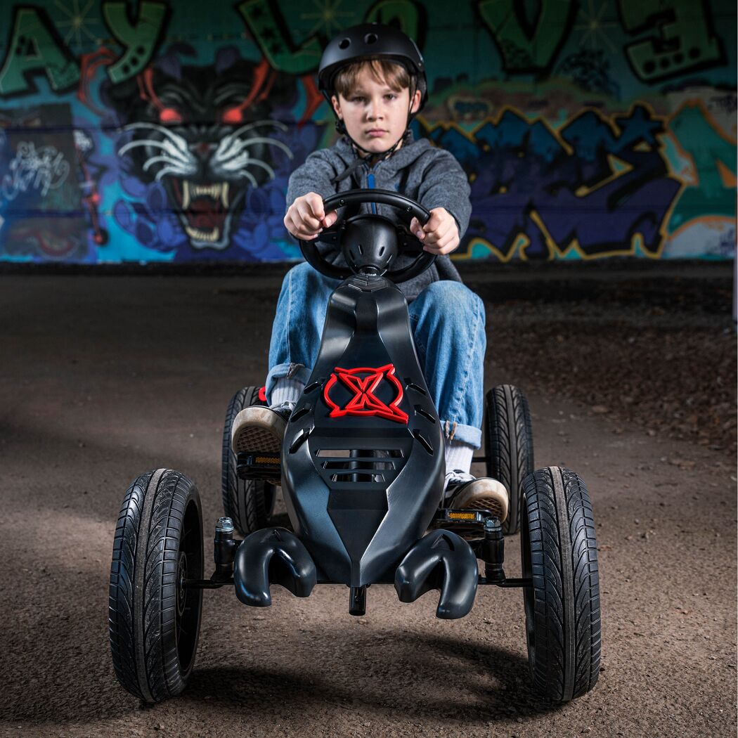 Kind mit Helm fährt Go-Kart