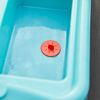 Blaues Plastikbecken mit rotem Stöpsel