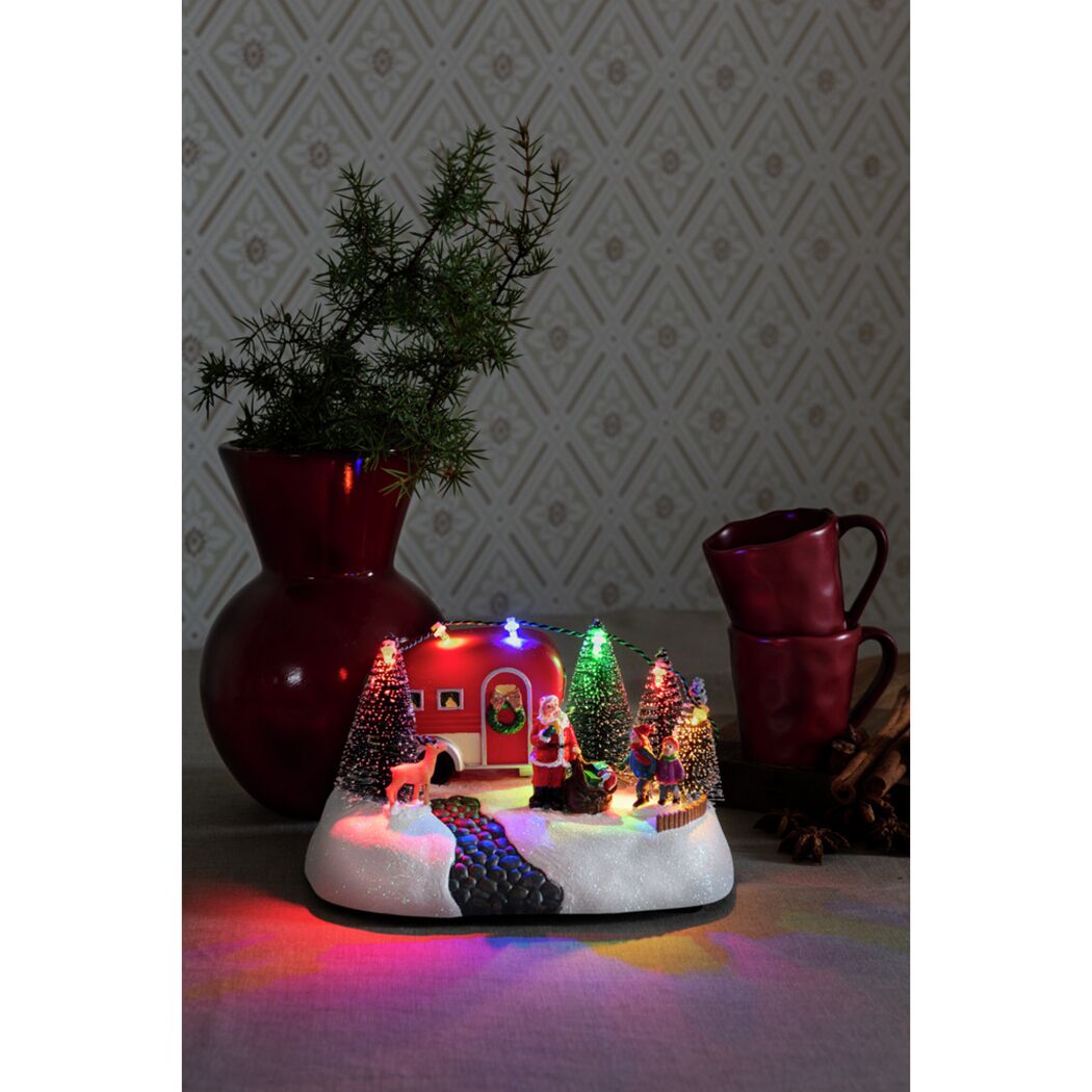Weihnachtliche Szene mit beleuchtetem Wohnwagen