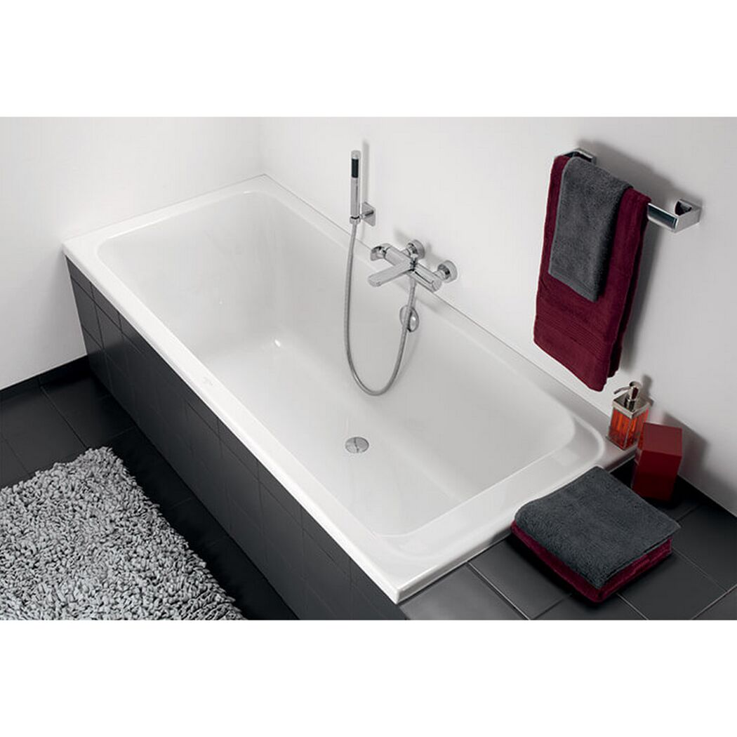 Weiße Badewanne mit Handbrause und Handtuchhalter
