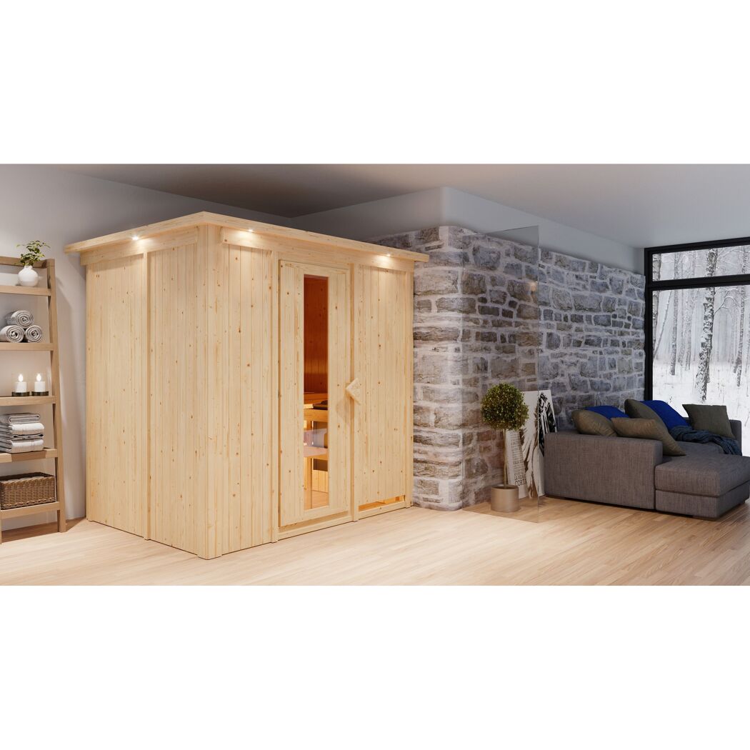 Sauna Aitana Front9KW natur in einem Raum mit Sofa und Steinwand