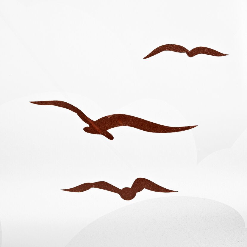 Drei Möwen fliegen über dem Meer.