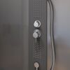 Schwarze Duschwand mit silbernen Armaturen.