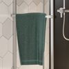 Grünes Handtuch auf Handtuchhalter im Badezimmer