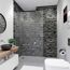 Modernes Badezimmer mit grauer Duschrückwand und Holzwandregal.