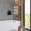 Badezimmer mit Badewanne und schwarzer Duschwand