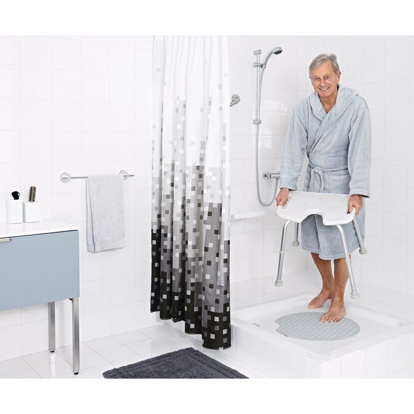 Person stellt Duschhocker in die Dusche