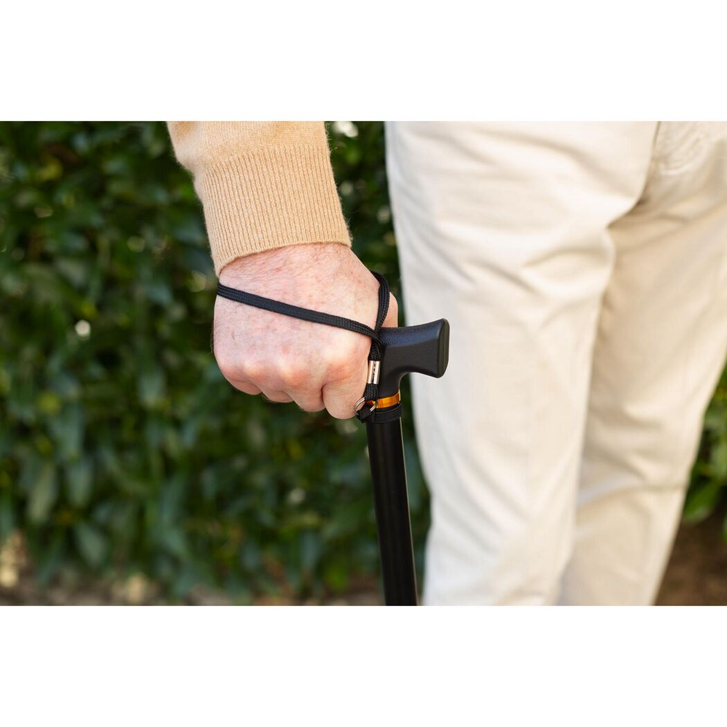 Person hält einen schwarzen Gehstock mit Handschlaufe.