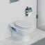 Weißes WC mit geschlossenem Deckel und Toilettenpapierhalter.