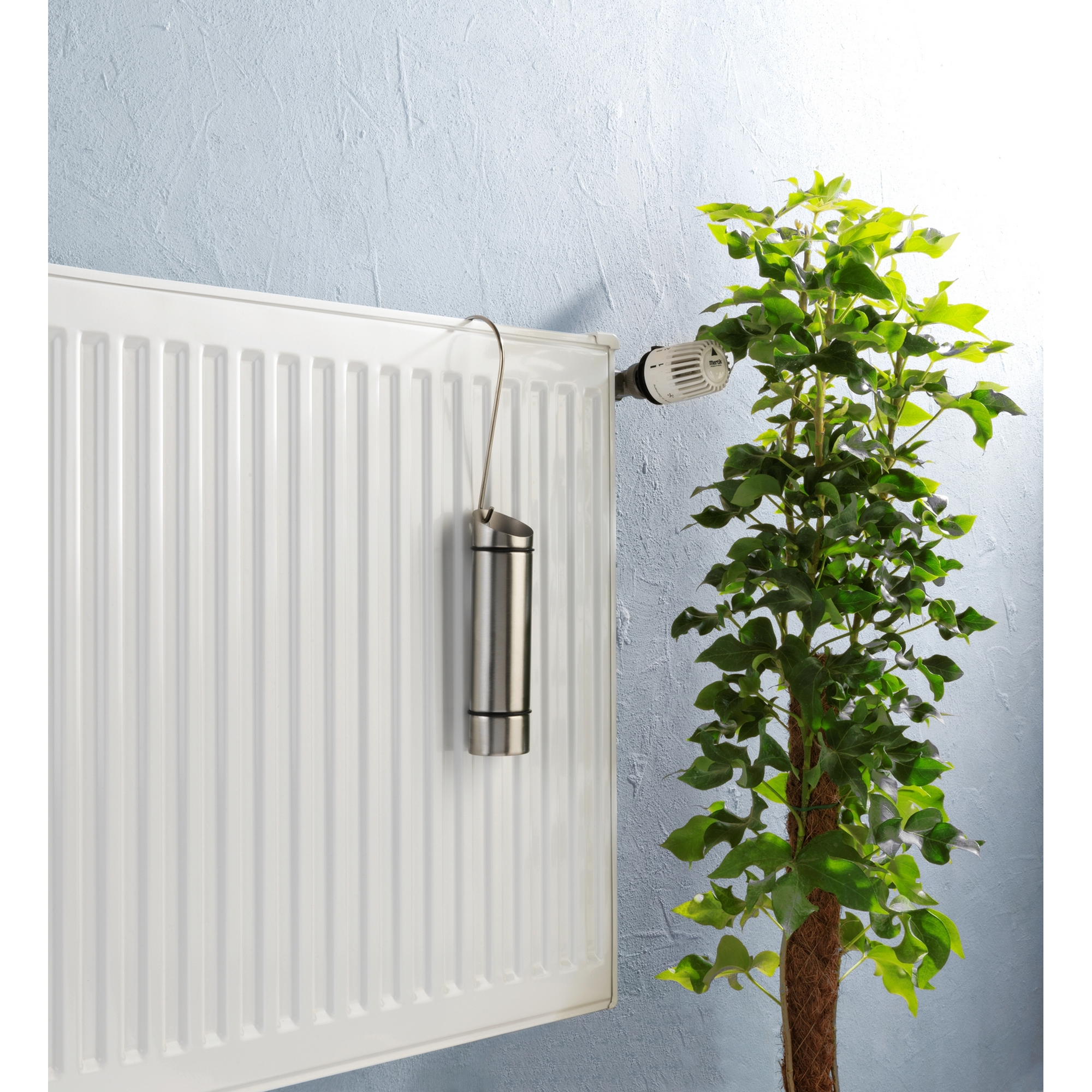 Luftbefeuchter aus Edelstahl an weißer Heizung