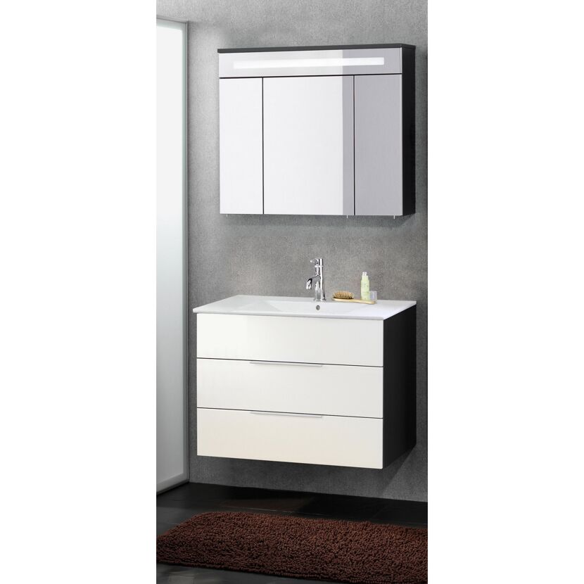 Weiß-schwarzer Waschtisch mit Spiegelschrank und braunem Badvorleger.