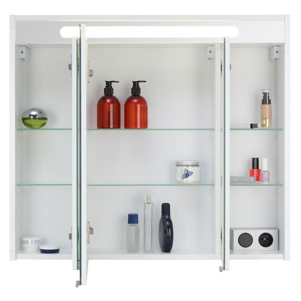 Weißer Spiegelschrank mit Kosmetikartikeln und Steckdose.