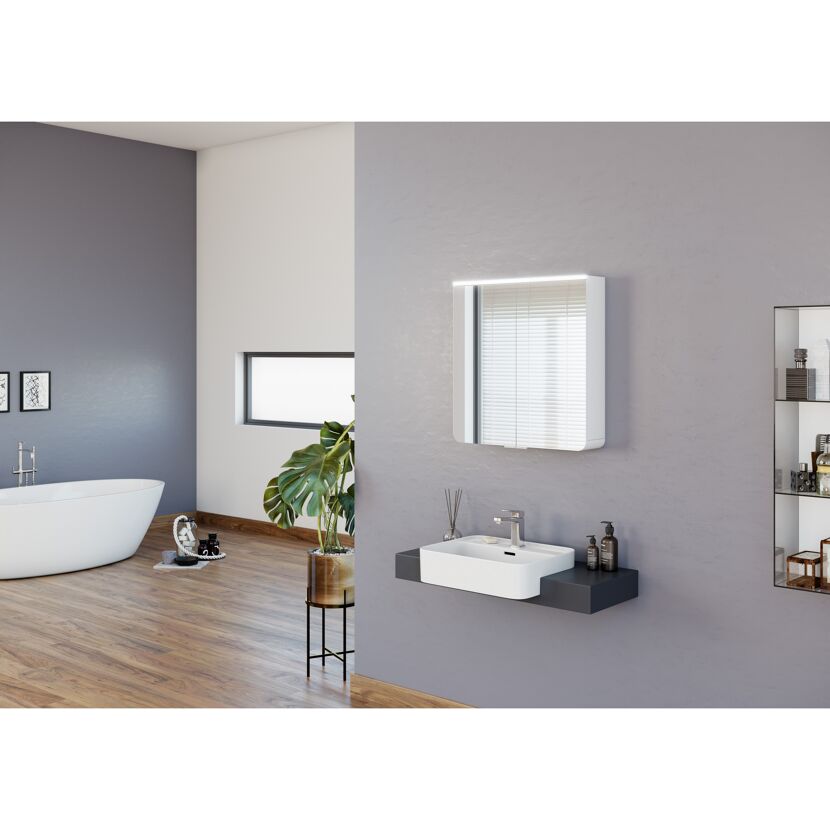 Badezimmer mit Spiegelschrank, Waschbecken und Badewanne.