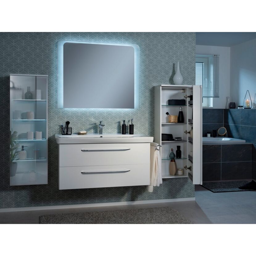Weißer Waschtisch mit Spiegelschrank, daneben Badewanne
