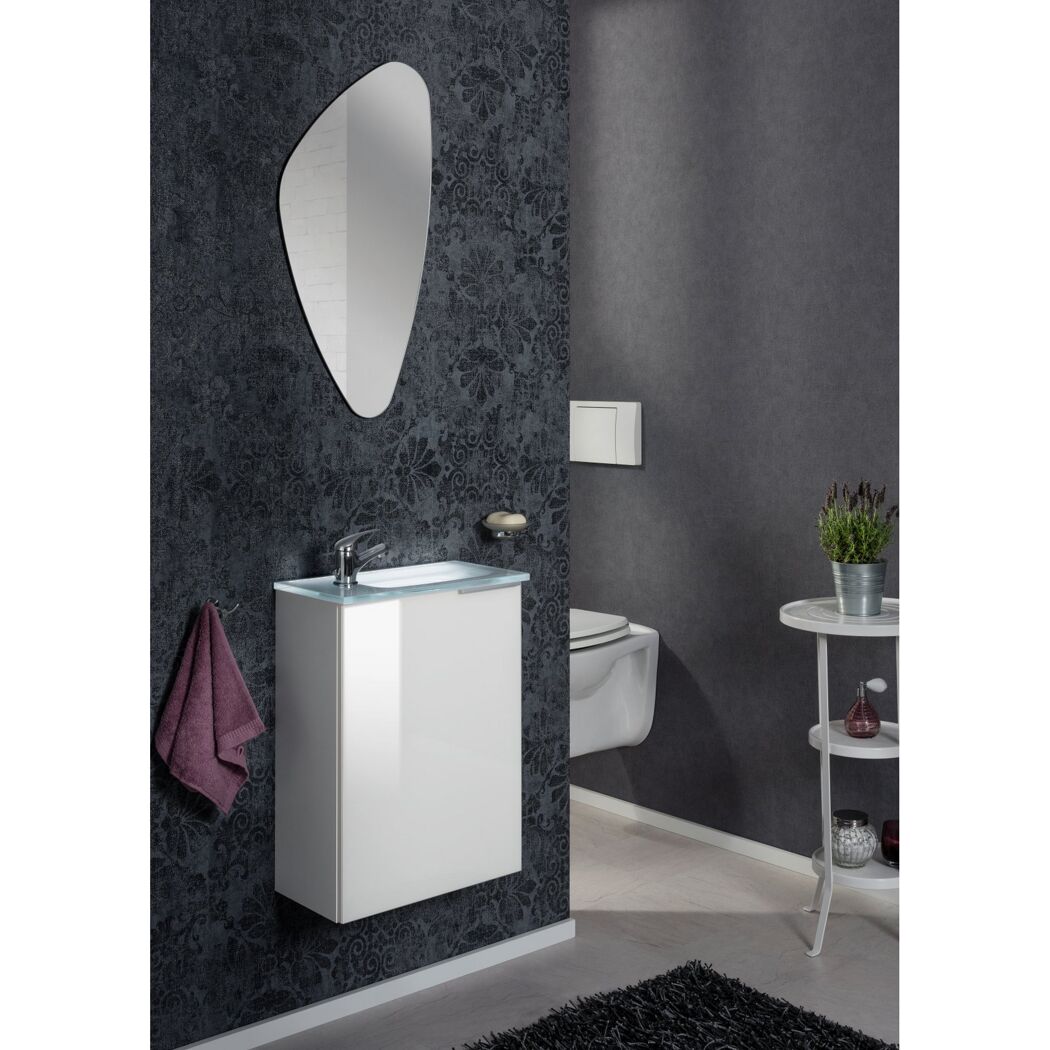 Badezimmer mit weißem Waschbeckenunterschrank und asymmetrischem Spiegel.