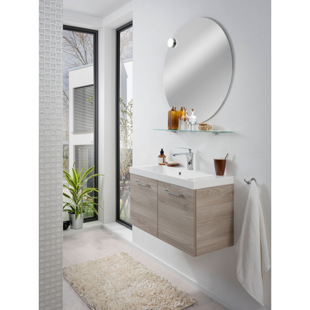 Badezimmer mit rundem Spiegel, Waschbeckenunterschrank und Handtuch
