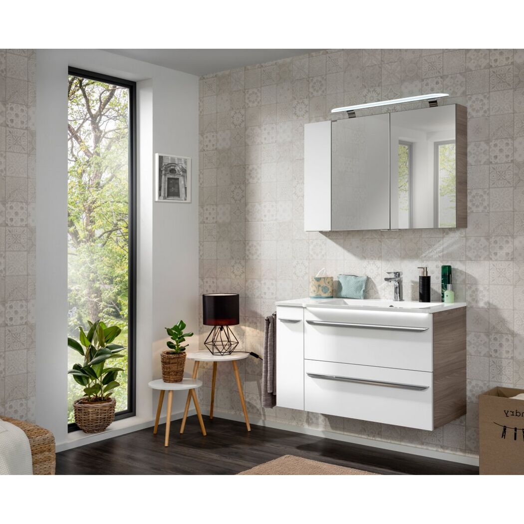 Modernes Badezimmer mit weißem Waschbecken und Spiegelschrank.