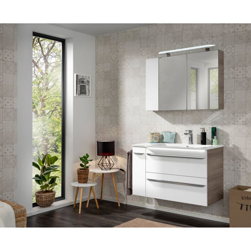 Modernes Badezimmer mit weißem Waschbecken und Spiegelschrank.