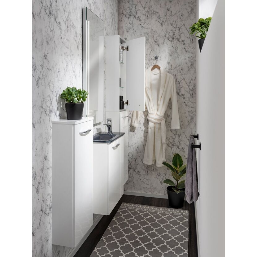 Weißes Badezimmer mit geöffnetem Spiegelschrank und Bademantel.