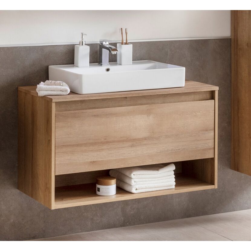 Waschbeckenunterschrank aus Holz mit Waschbecken, Handtüchern und Badutensilien.
