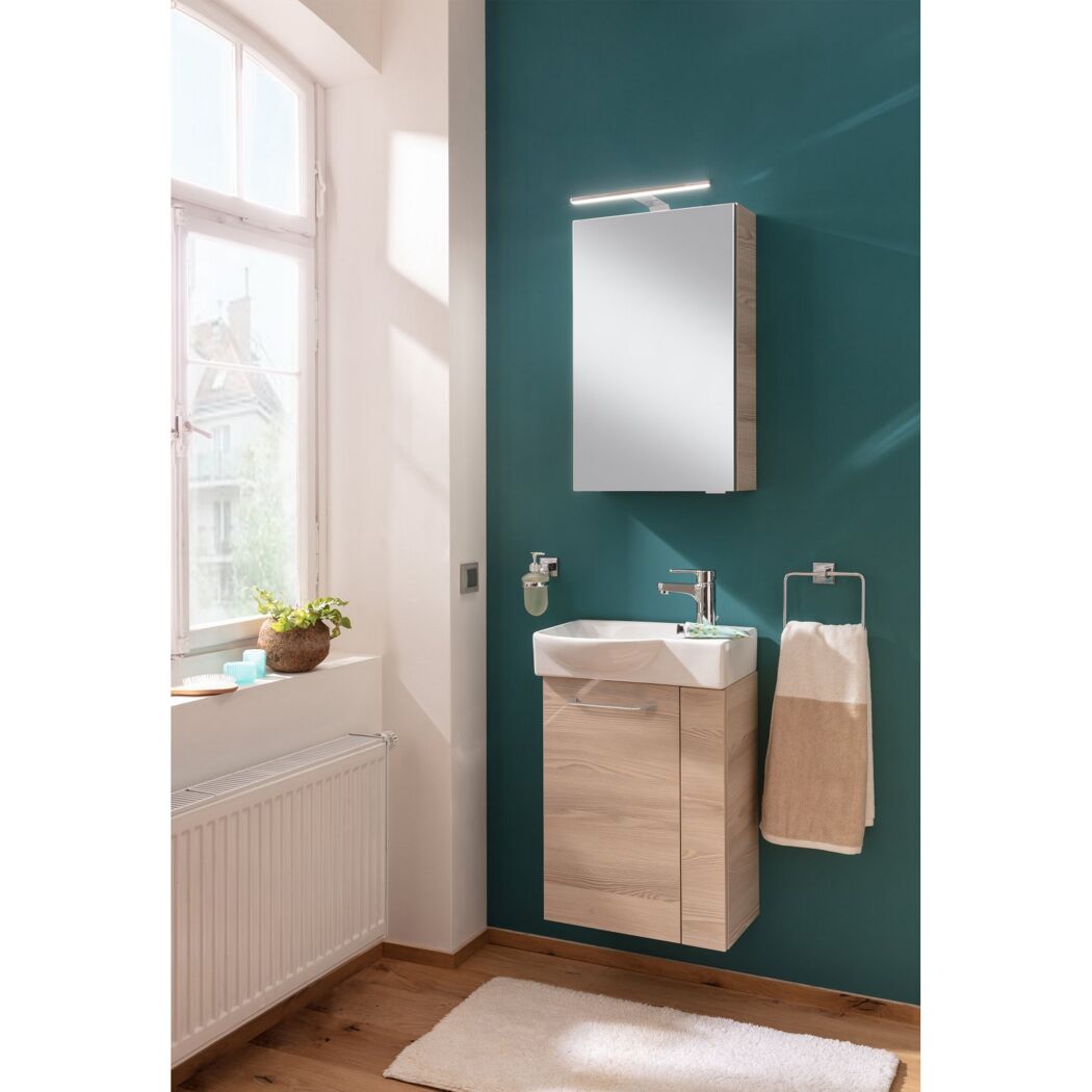 Badezimmer mit Waschbecken, Spiegelschrank und Handtuch