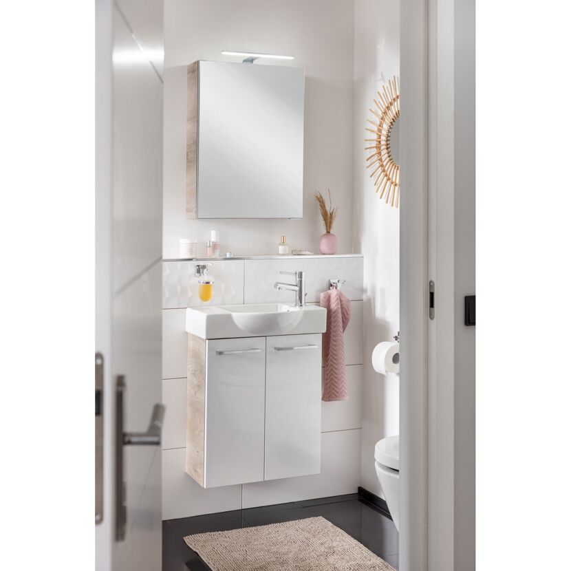 Weißer Waschtisch mit Spiegelschrank und Handtuch