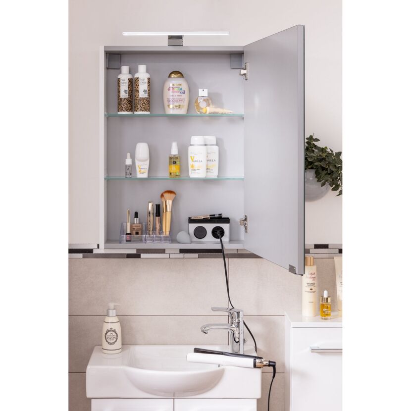 Badschrank mit Spiegel, Kosmetikartikeln und Glätteisen