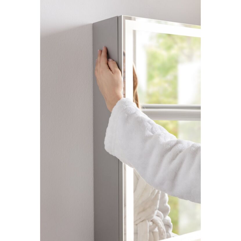 Person berührt Spiegelschrank FOTON