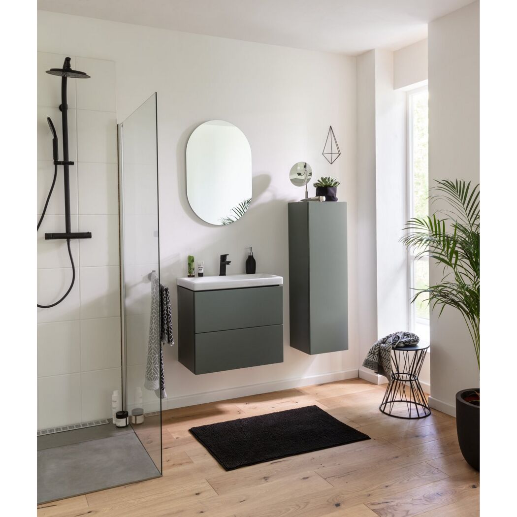 Modernes Badezimmer mit grünem Waschbeckenunterschrank und schwarzer Duscharmatur.