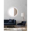 Runder LED-Spiegel über blauem Sofa