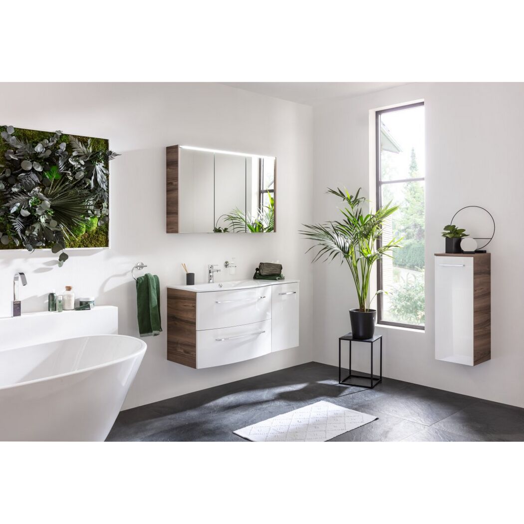 Modernes Badezimmer mit weißen Möbeln, grünen Pflanzen und grauen Fliesen.