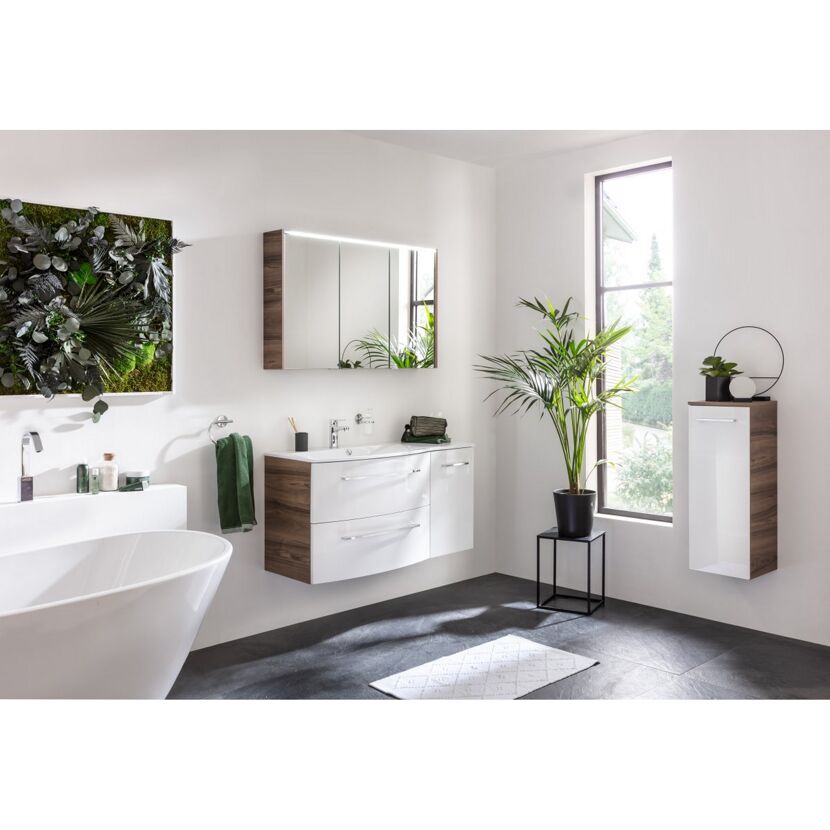 Modernes Badezimmer mit weißen Möbeln, grünen Pflanzen und grauen Fliesen.