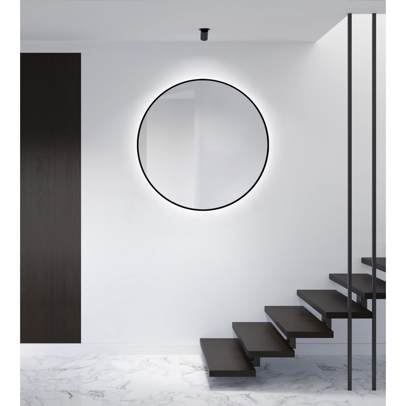 Runder LED-Spiegel an weißer Wand neben dunkler Treppe.