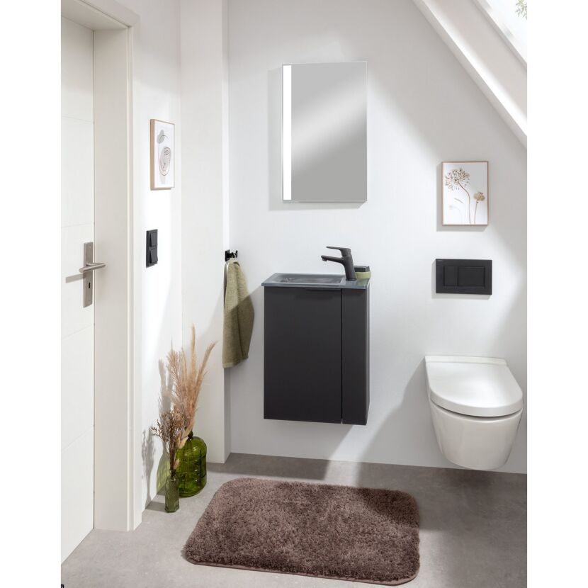 Kleines Badezimmer mit Waschbecken und Toilette