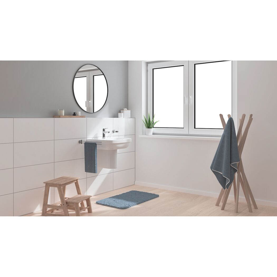 Modernes Badezimmer mit Waschbecken, Spiegel, Handtuchhalter und Hocker.