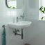 Waschbecken mit Armatur, Handtuch und Seifenspender.