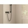 Schwarze Brausearmatur an beigefarbener Wand
