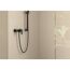 Schwarze Brausearmatur an beigefarbener Wand