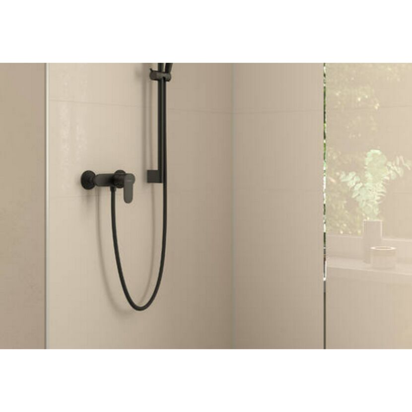 Schwarze Brausearmatur an beigefarbener Wand