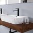 Waschbecken mit schwarzem Wasserhahn und Brille