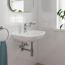 Weißes Waschbecken mit Armatur und Handtuch